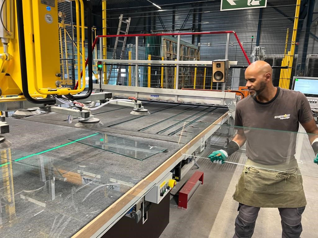 Werknemer snijdt de glasplaat