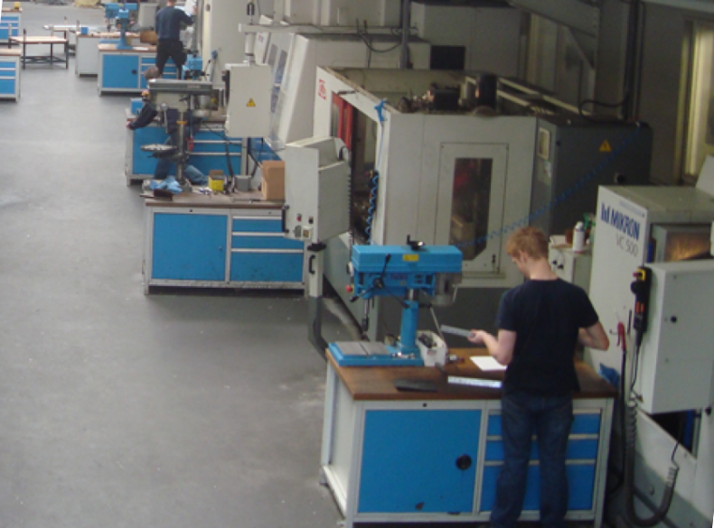 Werknemer aan het werk bij machines