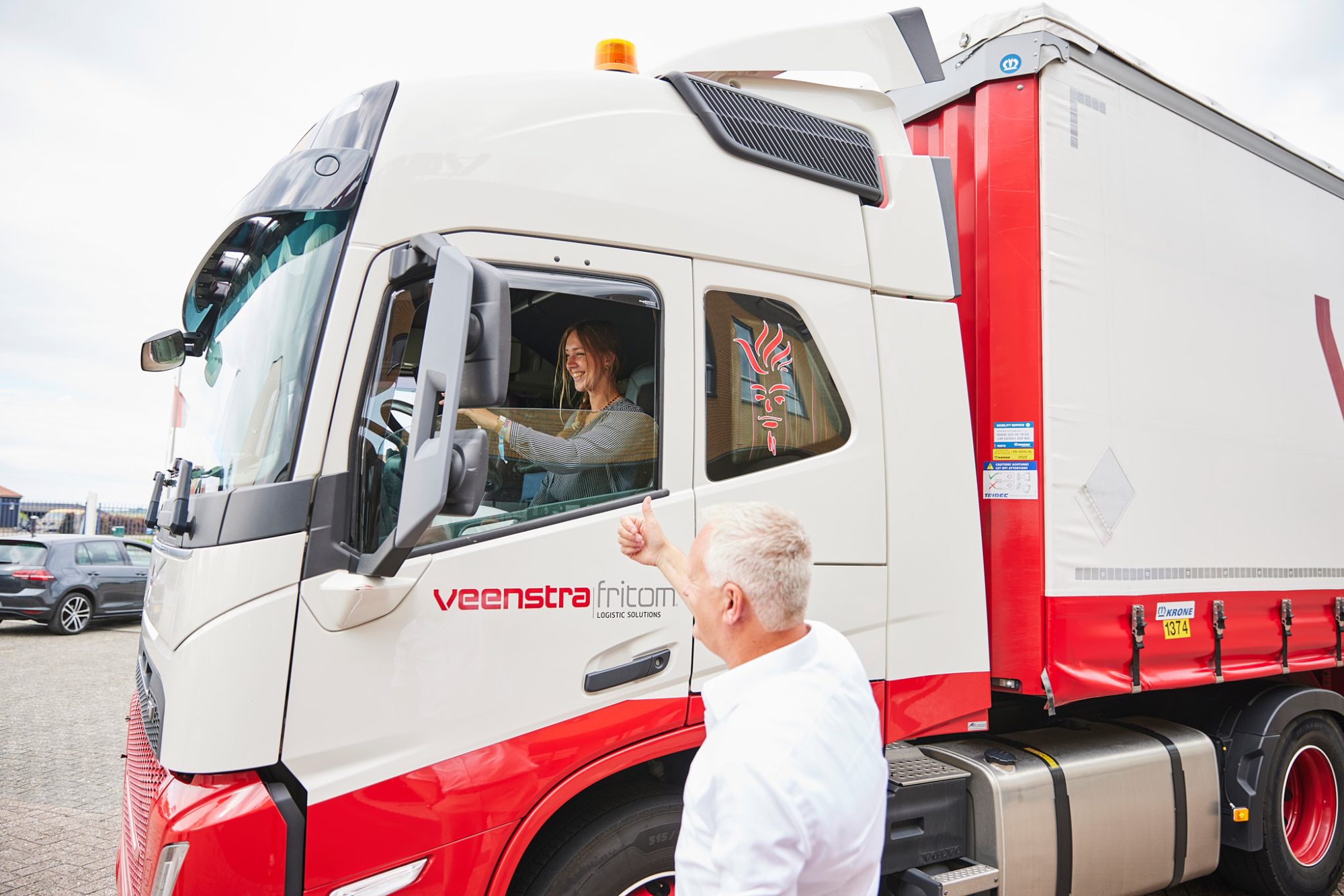 Vrouw achter het stuur bij vrachtwagen Veenstra|Fritom duimpje omhoog
